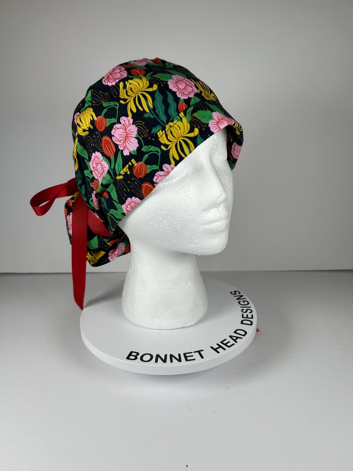 Black, pink, and yellow floral print women’s ponytail scrub cap, black floral scrub hat with ribbon ties, Bonnet Head Designs
