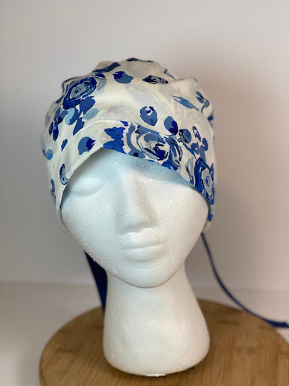 Shades of blue women’s floral scrub cap, blue, white, and navy floral ponytail scrub hat