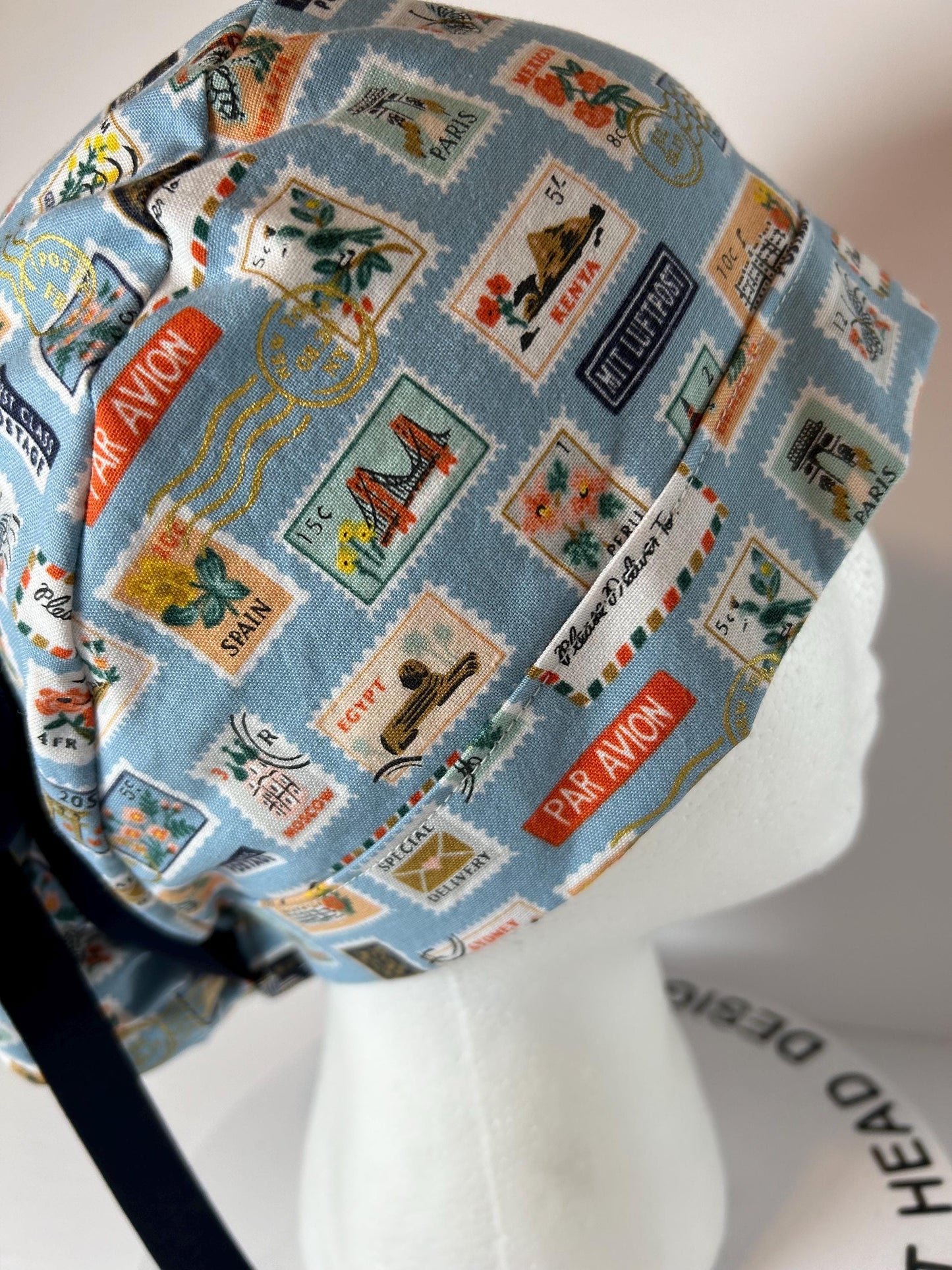 Rifle Paper travel stamp print scrub cap, blue and green travel stamps ponytail scrub hat, Bonnet Head Designs