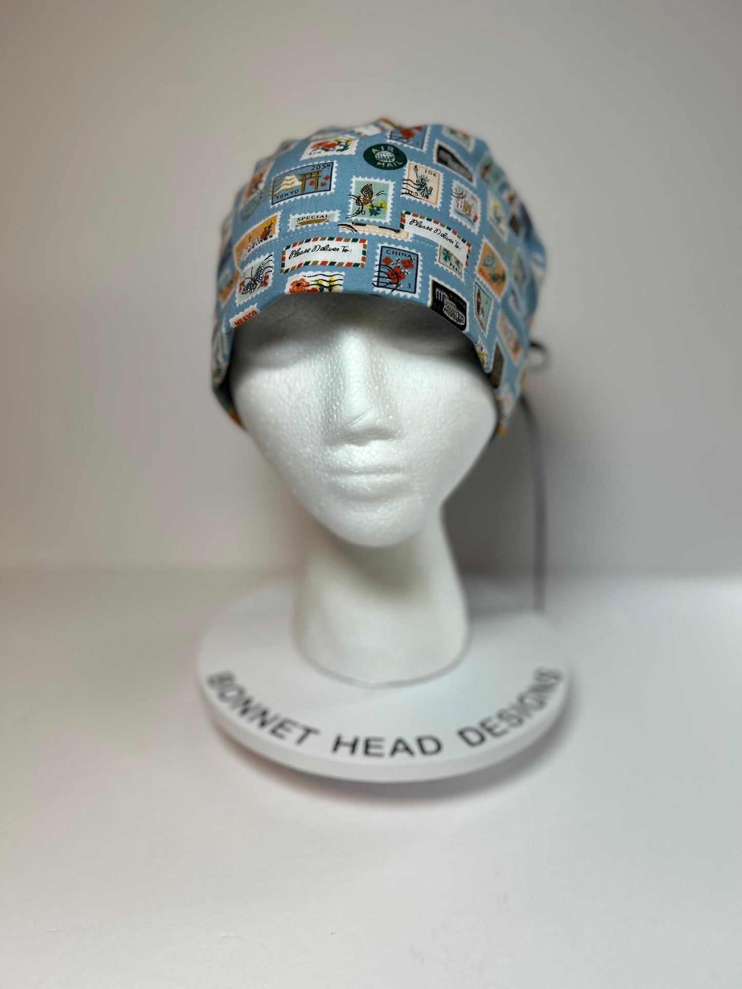 Rifle Paper travel stamp print scrub cap, blue and green travel stamps ponytail scrub hat, Bonnet Head Designs