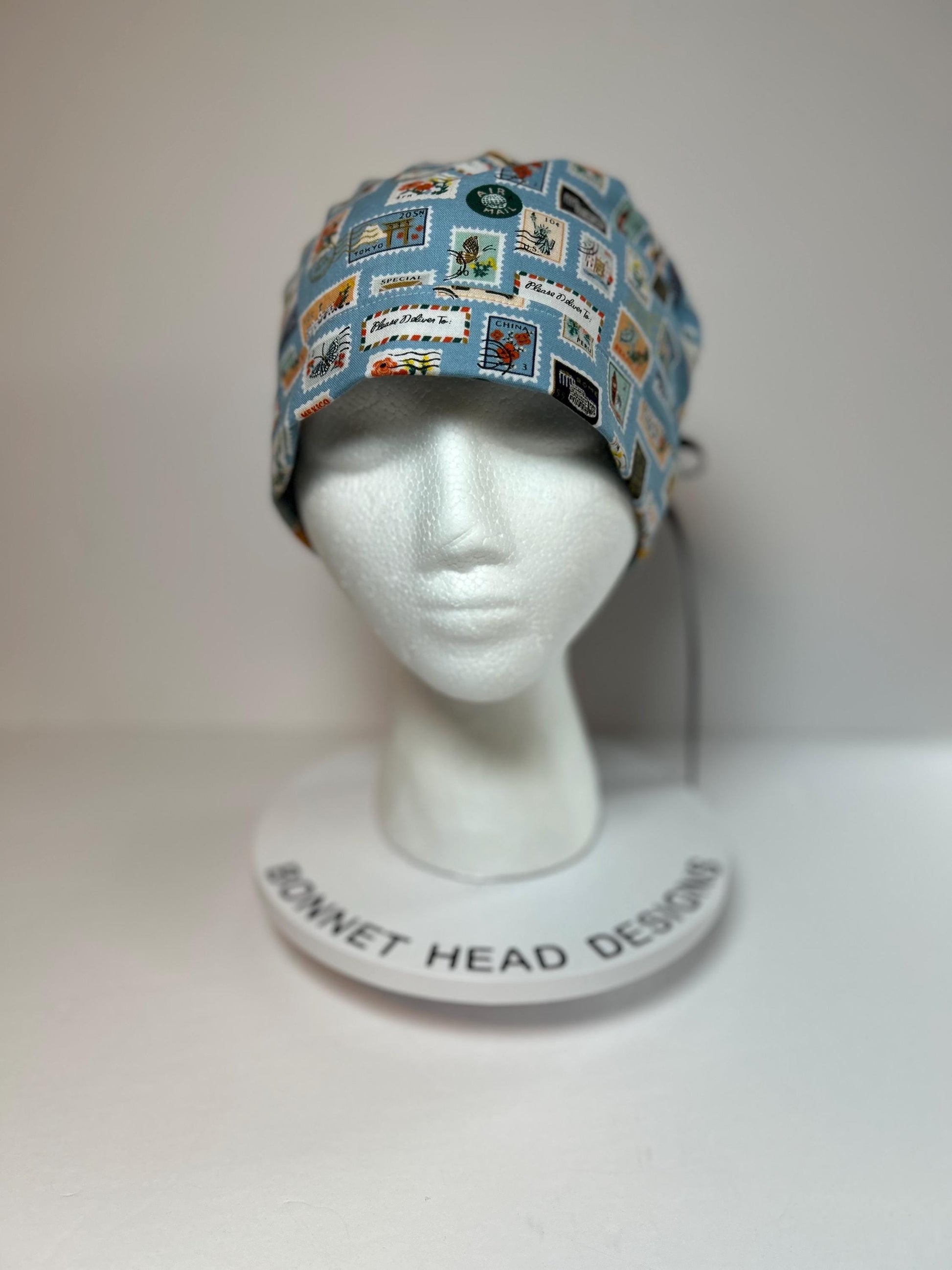Rifle Paper travel stamp print scrub cap, blue and green travel stamps ponytail scrub hat, Bonnet Head Designs