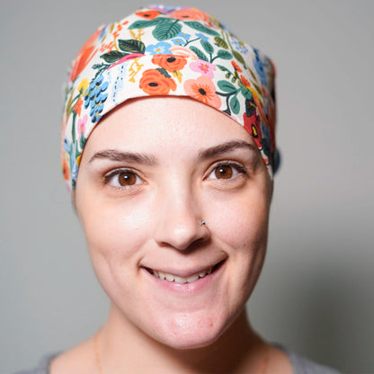 A woman with a floral patterned headband and a warm, friendly smile.